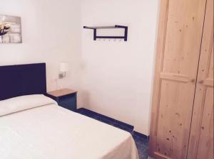 ネルハにあるRosales Apartment with balcony by Centrall alquileres turísticosの白いベッドと木製のドアが備わるベッドルーム1室が備わります。