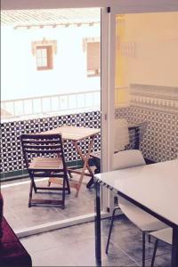 eine Terrasse mit einem Tisch und einem Stuhl in einem Zimmer in der Unterkunft Rosales Apartment with balcony by Centrall alquileres turísticos in Nerja