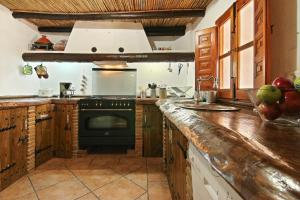 a kitchen with a black stove top oven next to a counter at Loma Los Pelones 78 in Viñuela