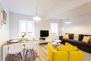 リスボンにあるWHome | Alfama Premium Apartmentのリビングルーム(ソファ、テーブル、黄色い椅子付)