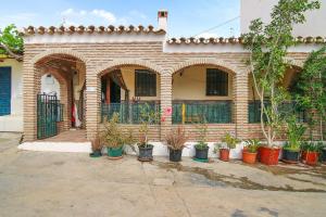 una casa de ladrillo con un montón de macetas en Loma Los Pelones 78, en Viñuela