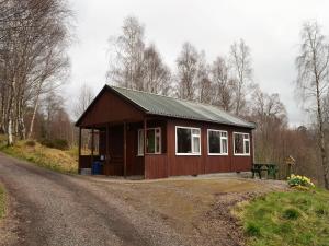 a small cabin on the side of a dirt road at Faichemard Farm Chalets in Invergarry