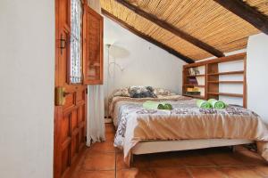 Un dormitorio con una cama con un perro. en Loma Los Pelones 78, en Viñuela