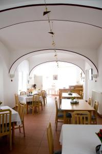 ein Restaurant mit Tischen und Stühlen und einem großen Torbogen in der Unterkunft Schloss Gumpoldskirchen in Gumpoldskirchen
