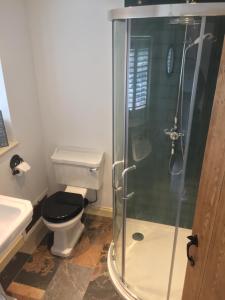 a bathroom with a toilet and a glass shower at The Stables at the Old Vicarage in Lincoln +24 photos
