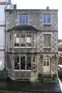 Una gran casa de ladrillo con ventanas y una puerta en Totters Hostel, en Caernarfon