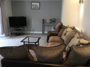 a living room with two couches and a television at Llewellyn Avenue Apartment in Llandudno