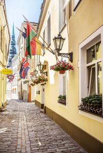 a street in the city with flags on buildings at Old Riga Boutique Hotel "Vecriga" in Rīga