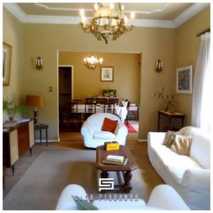 a living room with white furniture and a chandelier at Casa Piabanha - Centro Histórico in Petrópolis