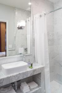 a white bathroom with a sink and a mirror at Monte Cristo Bed and Breakfast in San Francisco