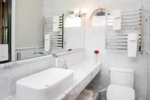 a white bathroom with a sink and a toilet at Monte Cristo Bed and Breakfast in San Francisco +53 photos