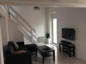 uma sala de estar com um sofá e uma televisão em Maison Banyuls em Banyuls-sur-Mer