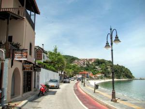 a street with cars parked on the side of a beach at Katerina Apartments in Agios Ioannis Pelio