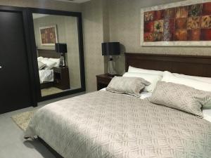 una camera con un grande letto e un grande specchio di LUJO CONFORT SEGURIDAD Quo 101 a Guayaquil