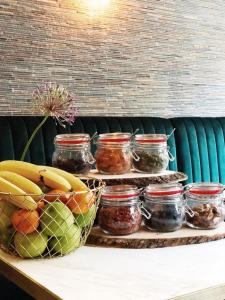a shelf with jars of jam and a bowl of fruit at Linden Hotel in Amsterdam