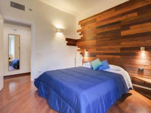 a bedroom with a blue bed with a wooden wall at Folia Domus - Vatican City in Rome