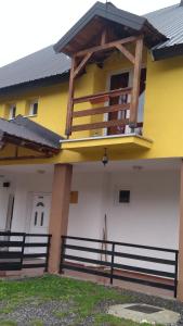 a yellow and white building with a balcony at Apartment Ana Marija in Mavrovo