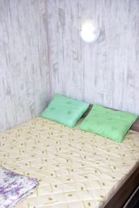 a bed with a blue and white comforter and pillows at Hostel Gurtyeva in Oryol