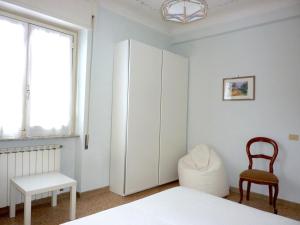 ローマにあるTommy Guest House Romaの白いキャビネットと椅子付きのベッドルーム1室