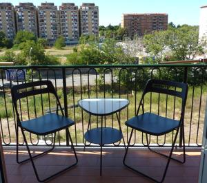 2 sedie e un tavolo sul balcone di Tommy Guest House Roma a Roma