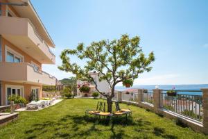 un árbol en un patio al lado de un edificio en Apartments Rakuljic, en Podstrana