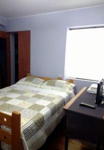 1 dormitorio con 1 cama y escritorio con teléfono en Kennedy Park 601 Apartment, en Lima