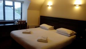 a bedroom with a large bed with two towels on it at The Brent Hotel - London - Wembley in London