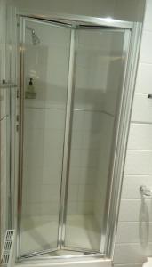 a shower with a glass door in a bathroom at The Brent Hotel - London - Wembley in London