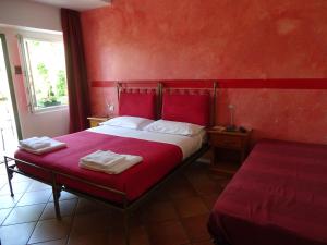 1 dormitorio rojo con 1 cama con 2 toallas en Casa Del Noce, en Rovereto