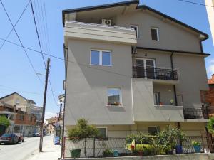 un edificio blanco alto en una calle de la ciudad en Accommodation Tanja, en Ohrid