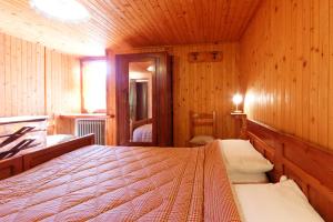 una camera da letto con un letto in una stanza di legno di Testa Grigia a Champoluc
