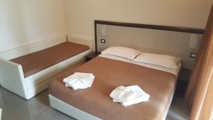 a bedroom with a bed with two towels on it at Park Hotel Cilento in Marina di Camerota
