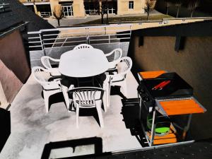 una mesa y sillas en un balcón con nieve en La Biasou, en Gèdre
