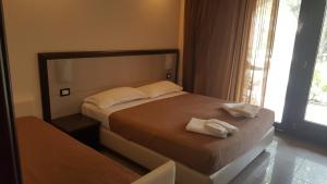 a bedroom with a bed with two towels on it at Park Hotel Cilento in Marina di Camerota