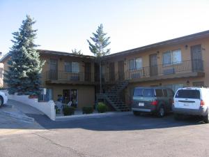 a building with cars parked in a parking lot at Heritage House Motel in Prescott