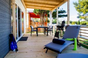 a porch with chairs and a table on a house at Adrijela Mobile Home in Jezera