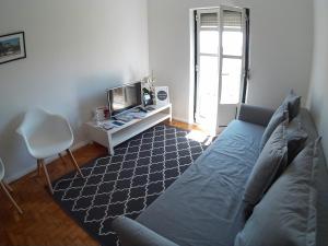 a living room with a blue couch and a tv at Olival 178 in Lisbon