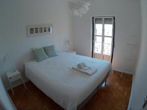 a bedroom with a white bed with a hat on it at Olival 178 in Lisbon