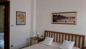 バルドリーノにあるMatteotti Houseのベッドルーム1室(ベッド1台付)が備わります。壁に絵が飾られています。