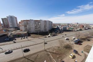 vistas a una calle de la ciudad con coches y edificios en Apartment Purple on Tereshkovoy 10/2 en Oremburgo