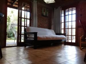 a bedroom with a bed in a room with windows at Girasoles Punta del Diablo in Punta Del Diablo