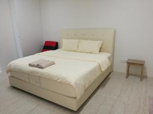 a white bed in a room with a white wall at By The Sea at Batu Ferringhi Penang in Batu Ferringhi