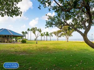 a park with a pavilion and palm trees and the ocean at Beachside Holiday Home in Redcliffe