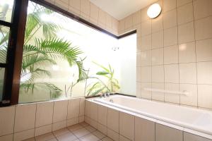 baño con bañera y ventana grande en Karin Design Cottage, en Onna