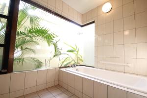 une salle de bain avec baignoire et une grande fenêtre dans l'établissement Karin Design Cottage, à Onna 75 autres photos