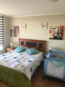 una camera da letto con un letto con una trapunta sopra di Algarrobo, Laguna bahí­a departamento 1303 & 302 ad Algarrobo