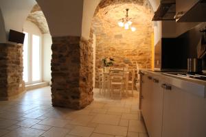 a kitchen with a stone wall and a table at Agriturismo Il Vecchio Mulino in Terzorio