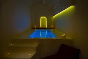 uma piscina num quarto com luzes e velas em Alma Libre Suites em Fira