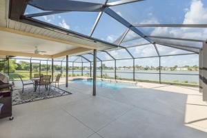 a glass house with a swimming pool and a patio at Lilsis by the Lake in Port Charlotte