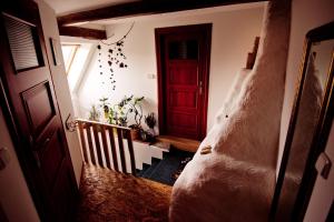 um quarto com uma cama grande e uma porta vermelha em Penzion PIŠLIKDUM em Stará Červená Voda